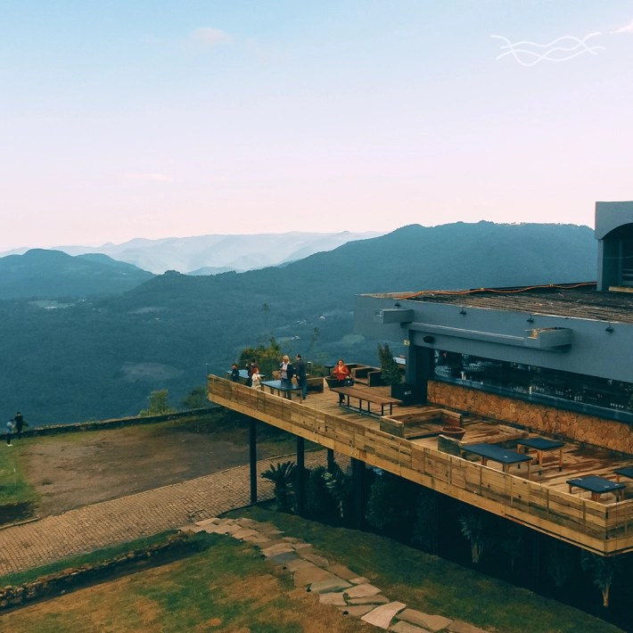 Restaurante com vista para as montanhas ao entardecer na laje de pedra.