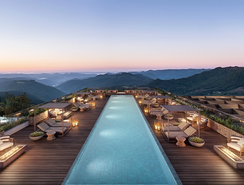 Vista da laje de pedra com piscina e montanhas ao fundo - Kempinski